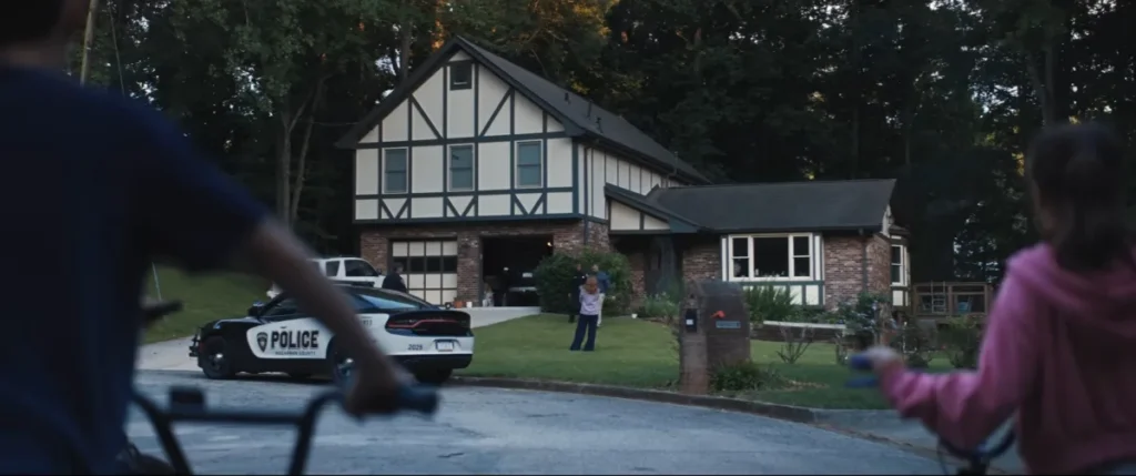Kids on bikes watching a police car outside a house, from the official Weapons trailer